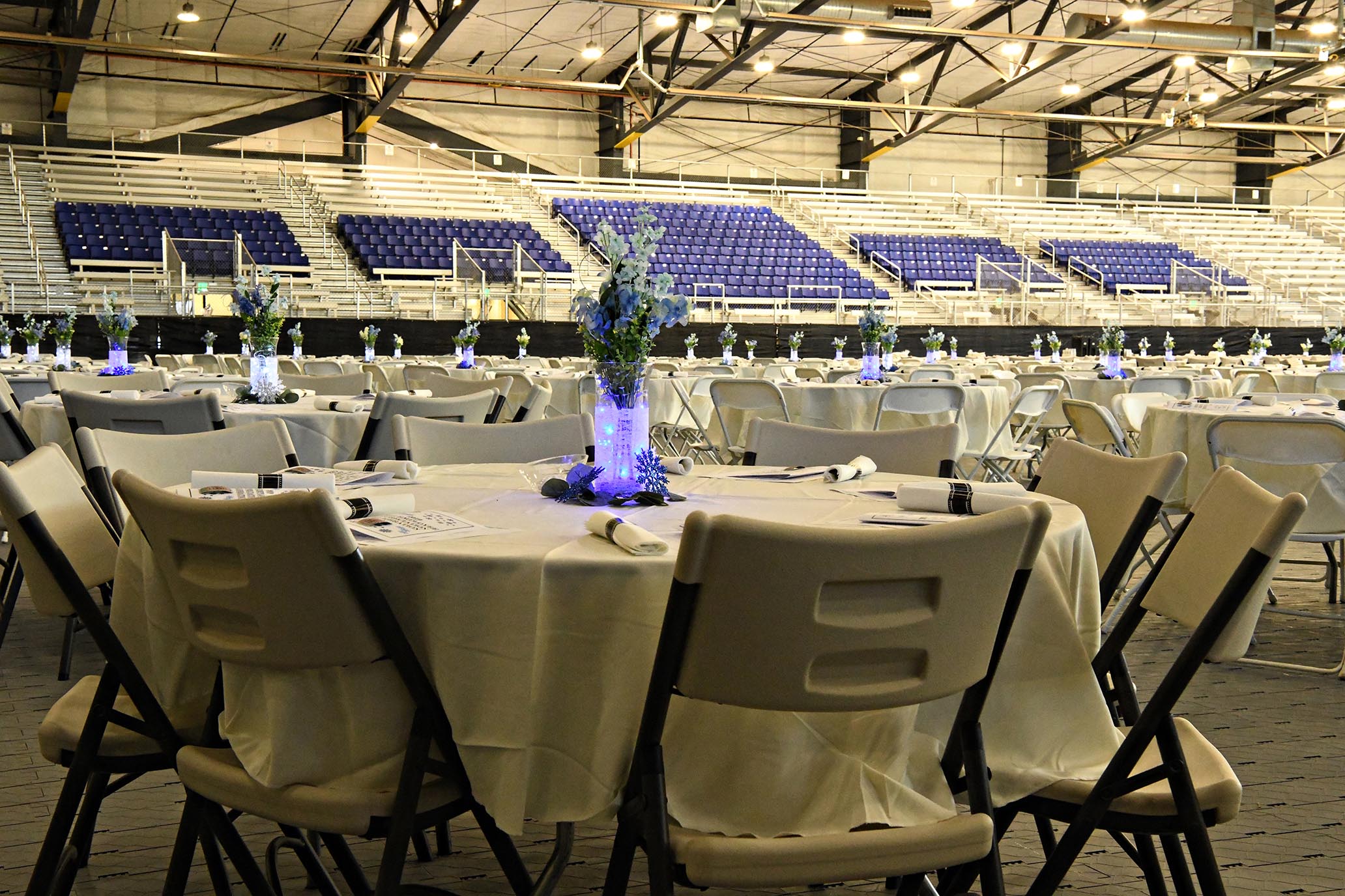 indoor arena set for party with white tablecloths