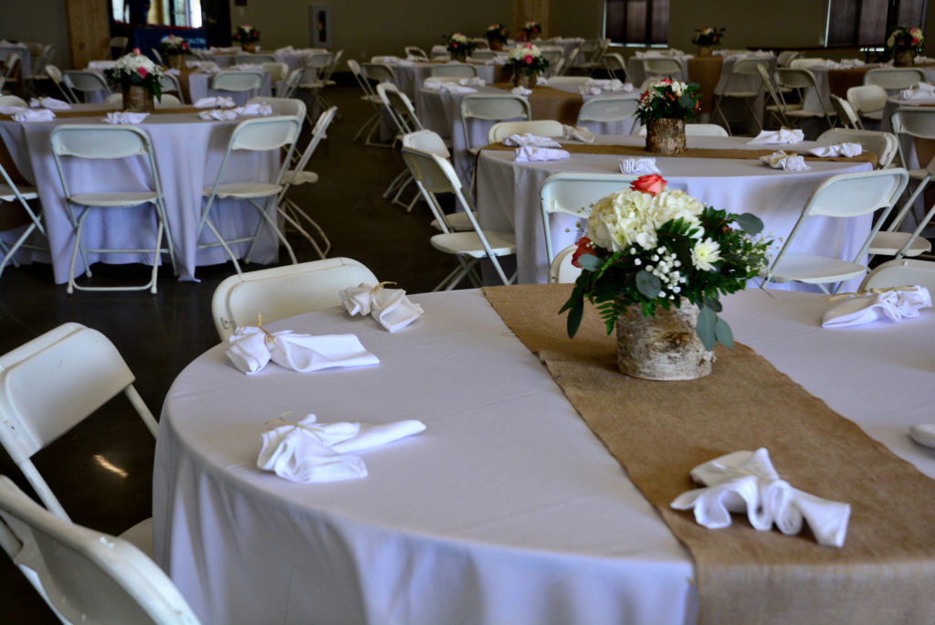 Banquet hall setup with white linens and flowers