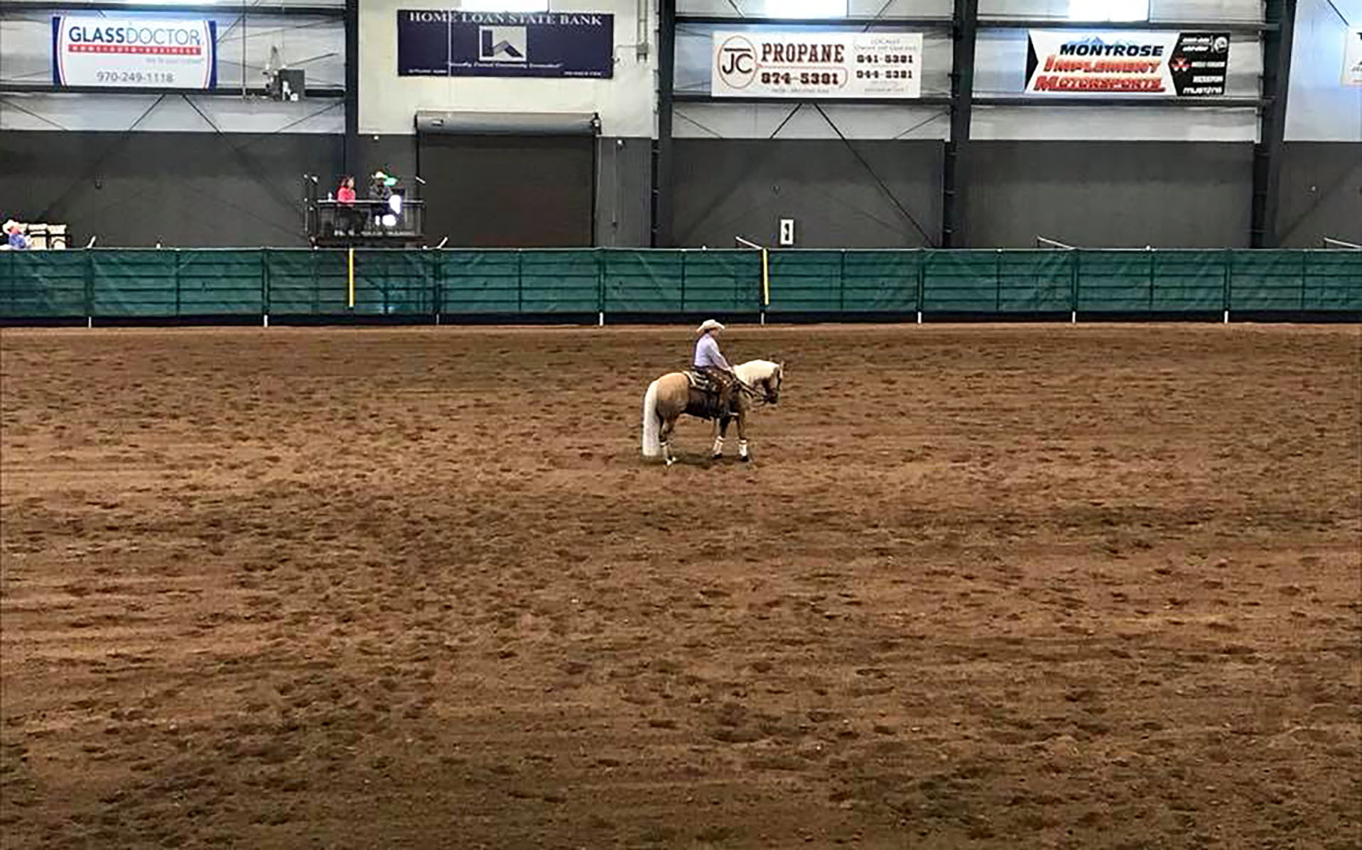 Horse with rider alone in indoor arena.